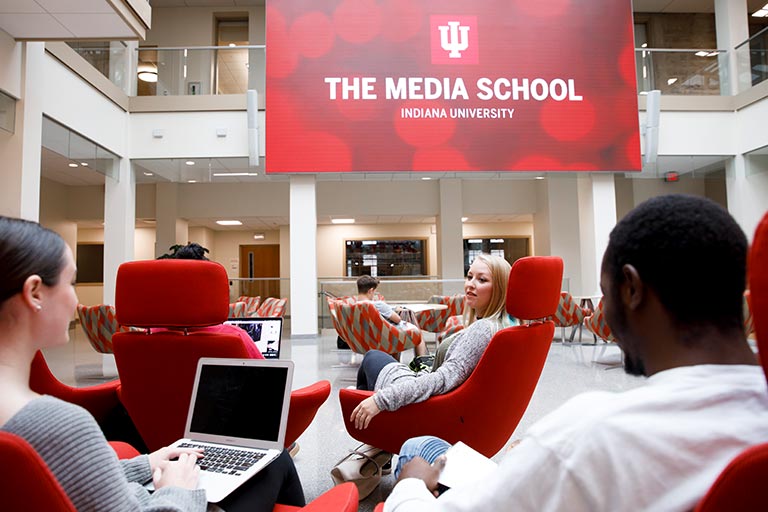 Students lounge and work on their laptops in the commons area of Franklin Hall.