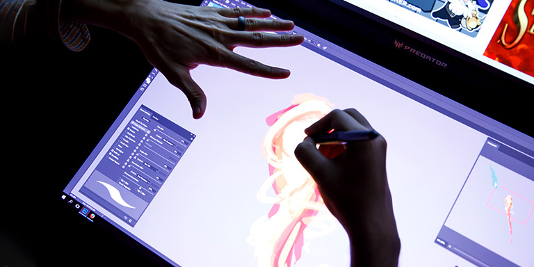 A student's hands as they work on a design on a writing tablet