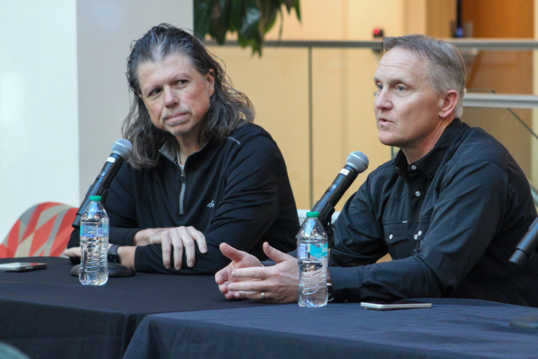 Two people speak at a panel.